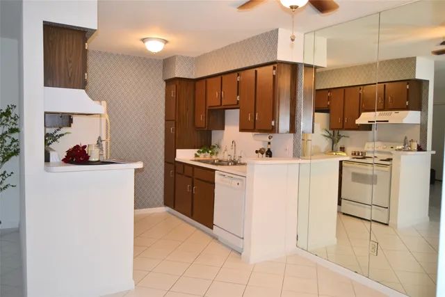 a kitchen with white cabinets and white appliances