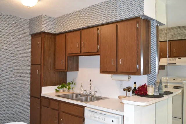 a kitchen with stainless steel appliances granite countertop a sink refrigerator and cabinets