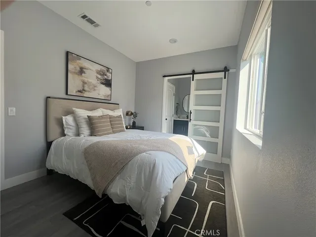 a bedroom with a bed and painting on the wall