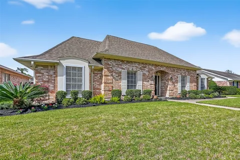 a view of a brick house with a yard