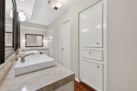 a en suite bathroom with a granite countertop sink and a mirror
