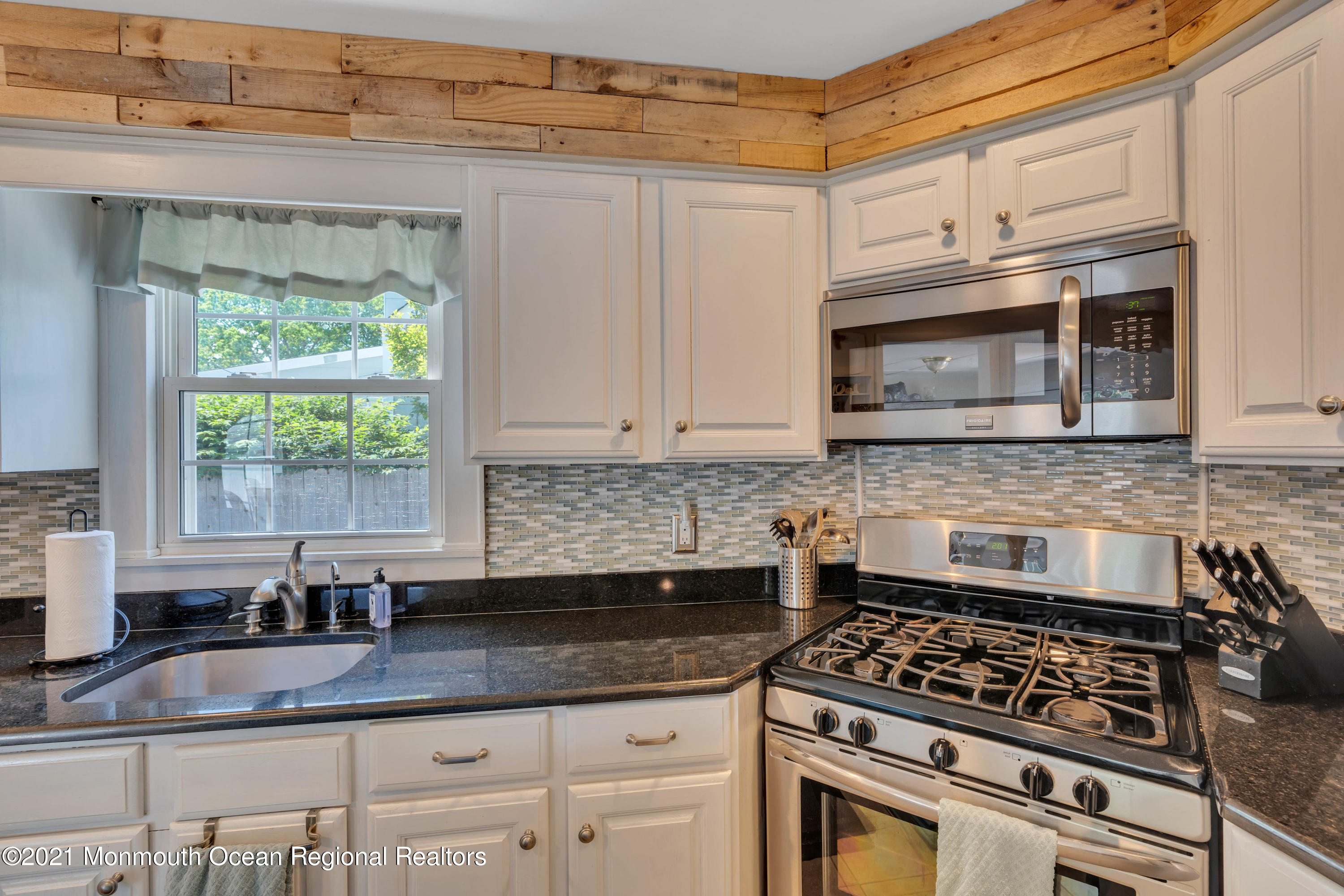 2212 Kenneth Road Point Pleasant, NJ 08742 - Photo 15 of 43 a kitchen with granite countertop a stove a sink and a microwave