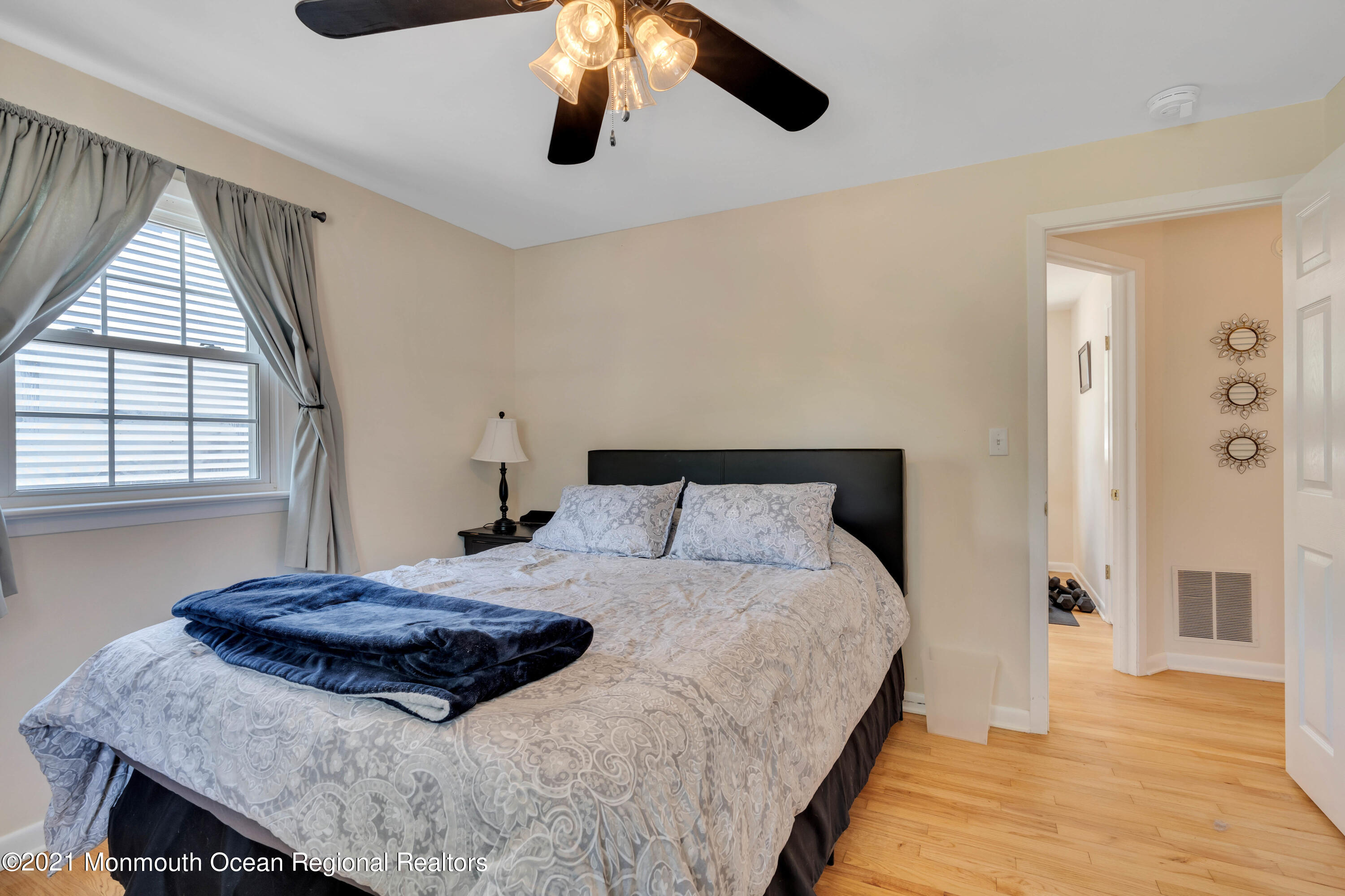 2212 Kenneth Road Point Pleasant, NJ 08742 - Photo 26 of 43 a bedroom with a bed and a chandelier