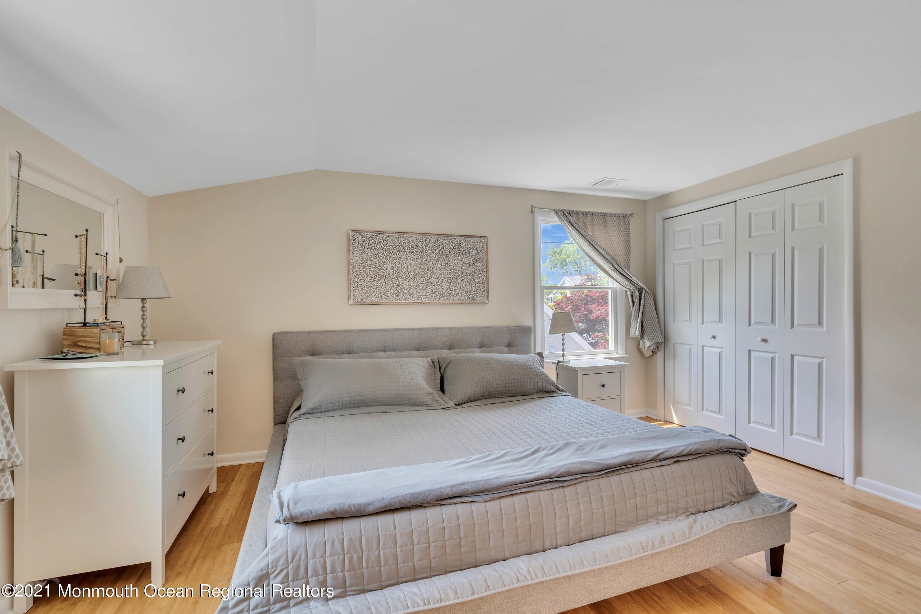 2212 Kenneth Road Point Pleasant, NJ 08742 - Photo 30 of 43 a bedroom with a large bed and a chandelier