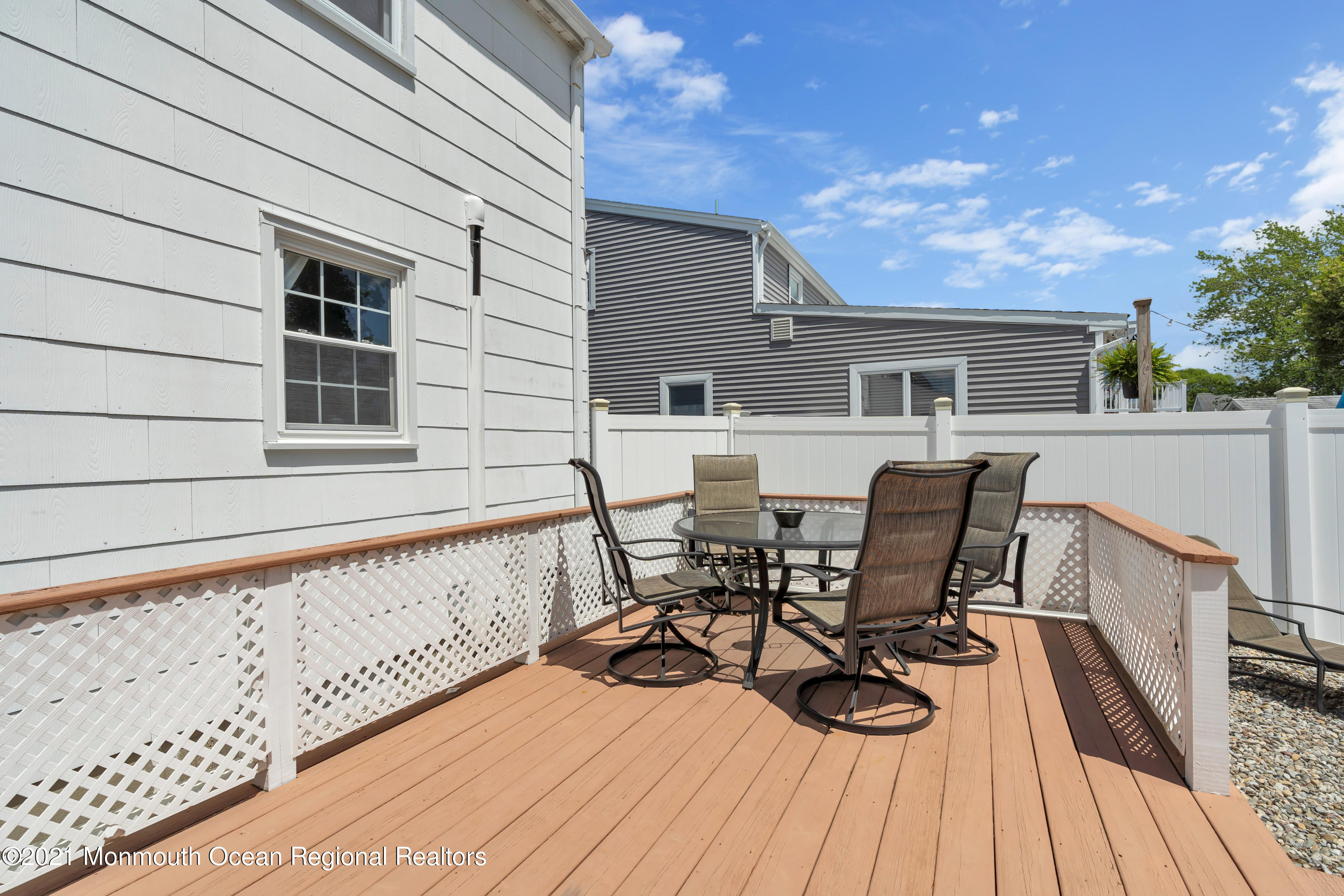 2212 Kenneth Road Point Pleasant, NJ 08742 - Photo 38 of 43 a view of a patio with table and chairs with wooden floor and fence
