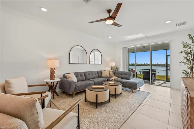 a living room with furniture a rug potted plant and a window