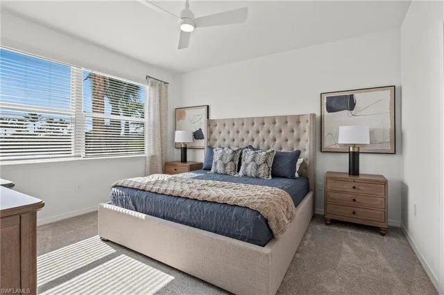 a bedroom with a bed lamp and a large window