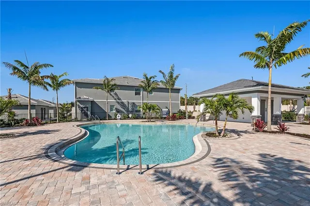 a view of a swimming pool with a lounge chair and potted plants