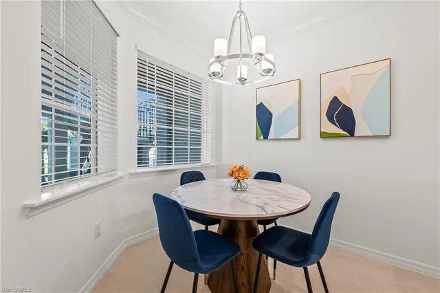 a view of a dining room with furniture a chandelier and wooden floor