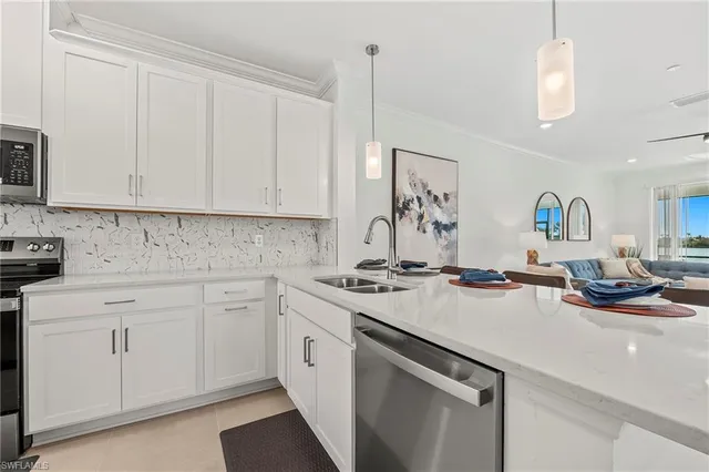 a kitchen with a sink dishwasher and white cabinets with wooden floor
