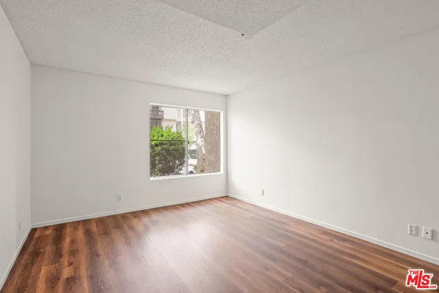 an empty room with wooden floor and window