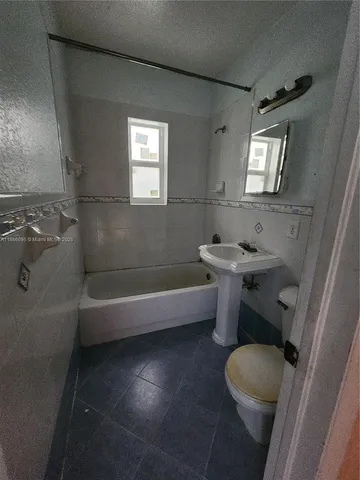 a bathroom with a sink a toilet and bathtub