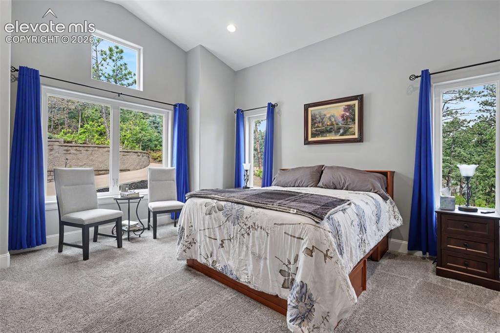 21 Leaming Road Colorado Springs, CO 80906 - Photo 32 of 48 Vaulted ceiling bedroom with large windows, an upper transom window, recessed lighting, and grey carpeting