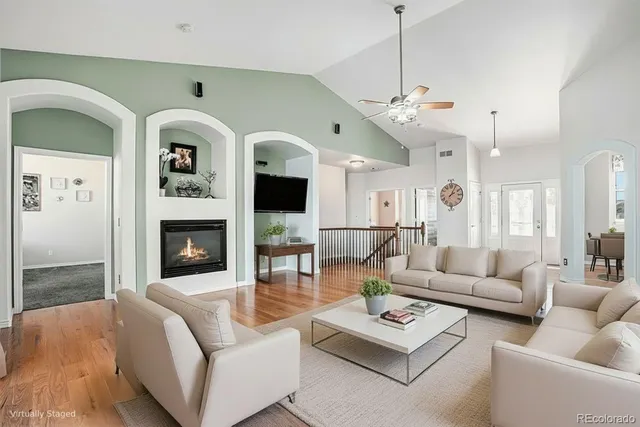 a living room with furniture a fireplace and a chandelier