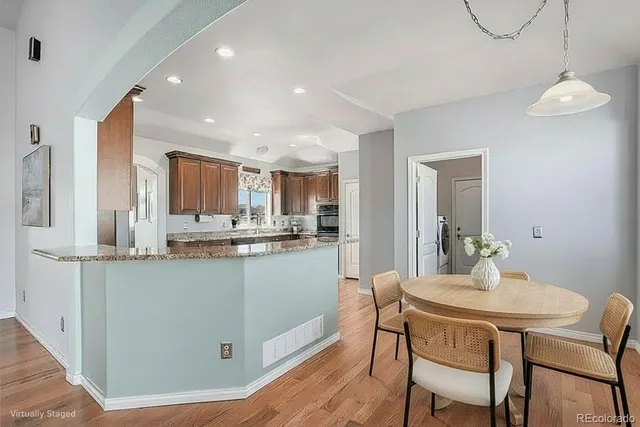 a kitchen with stainless steel appliances kitchen island granite countertop a dining table chairs and granite counter tops