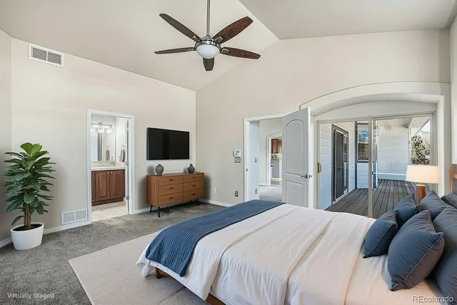 a bedroom with a large bed and a potted plant