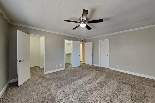 an empty room with wooden floor chandelier and windows