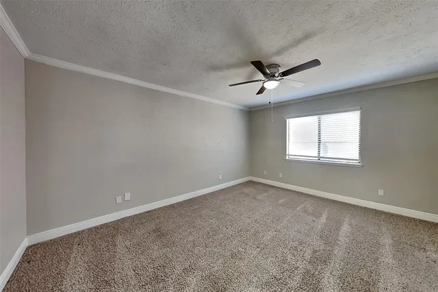 a view of a livingroom with a ceiling fan & windows