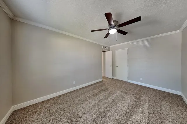 en empty room with ceiling fan and window