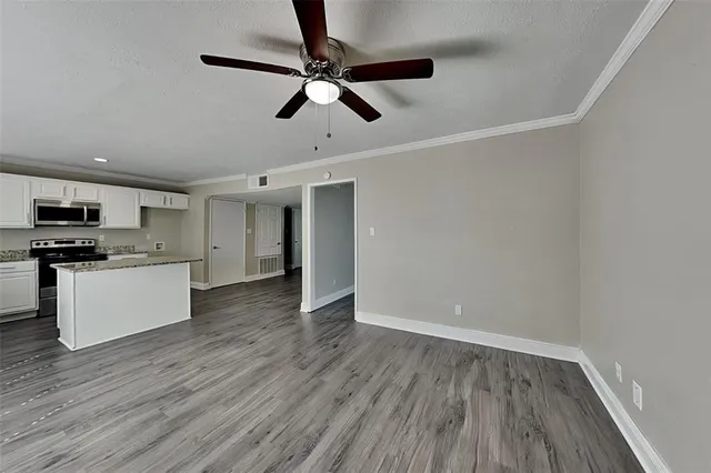 a view of kitchen with cabinets wooden floor and stainless steel appliances
