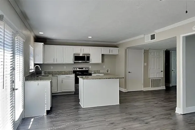 a kitchen with stainless steel appliances a refrigerator sink and microwave