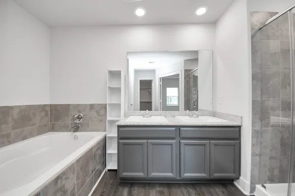 a bathroom with a granite countertop sink and mirror with bathtub