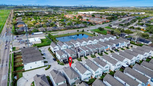 an aerial view of residential houses with outdoor space and river