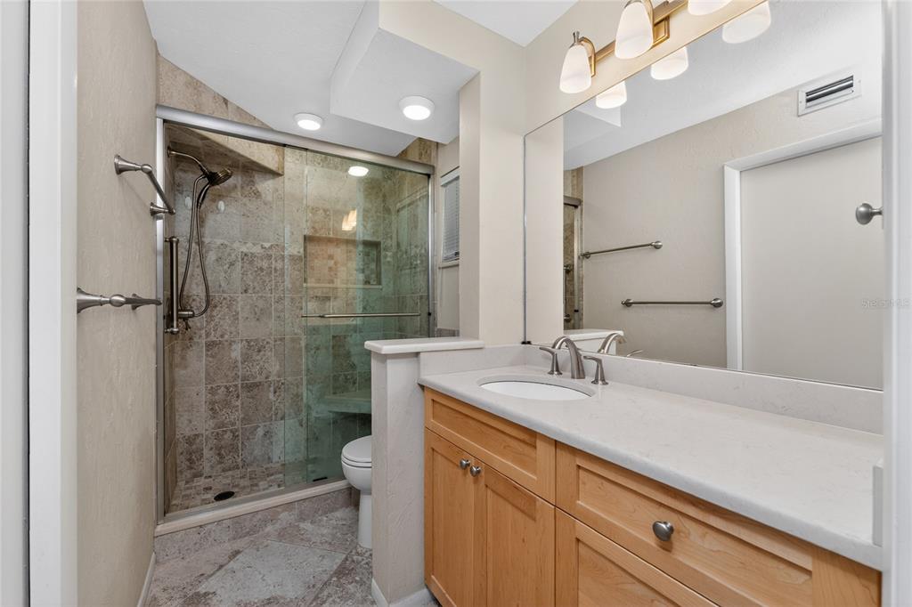 2955 North Beach Road, Unit B614 Englewood, FL 34223 - Photo 27 of 67 a bathroom with a shower sink vanity mirror and toilet