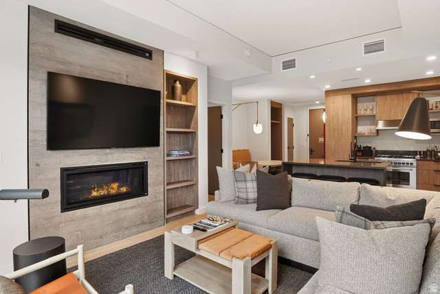 2417 West High Road, Unit 3210 Park City, UT 84098 - Photo 5 of 44 A linear gas fireplace and mounted television anchor the great room, with the kitchen open beyond.