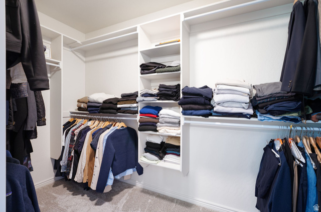 1712 Somerset Ridge Drive Draper, UT 84020 - Photo 38 of 76 Custom white built-in closet system with multiple shelving units and hanging rods, set against light-colored walls, with a gray carpeted floor