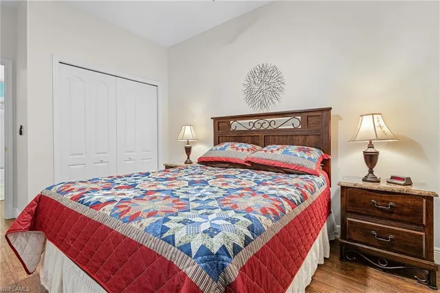 a bedroom with a bed and a lamp on dresser