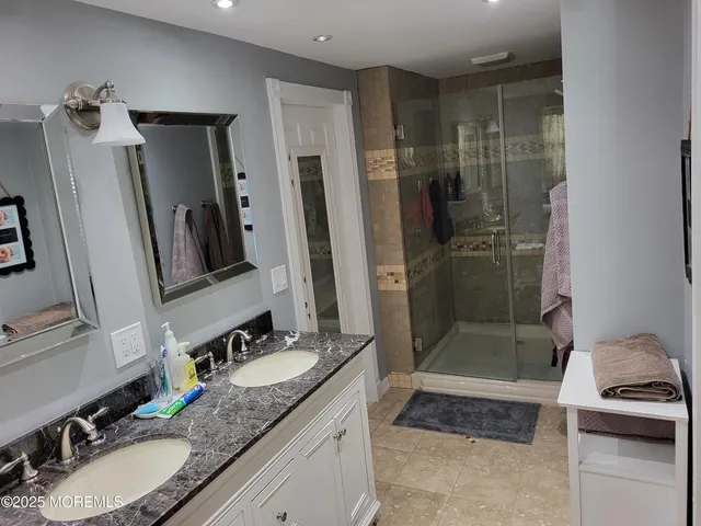 a bathroom with a granite countertop sink shower and a mirror