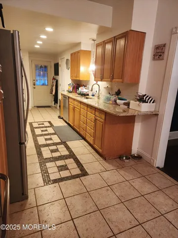 a kitchen with stainless steel appliances granite countertop a refrigerator and a stove
