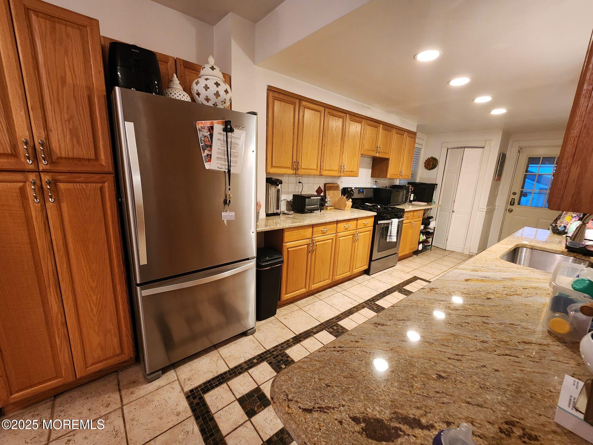 393 Bath Avenue Long Branch, NJ 07740 - Photo 15 of 22 a kitchen with stainless steel appliances granite countertop a refrigerator stove and sink