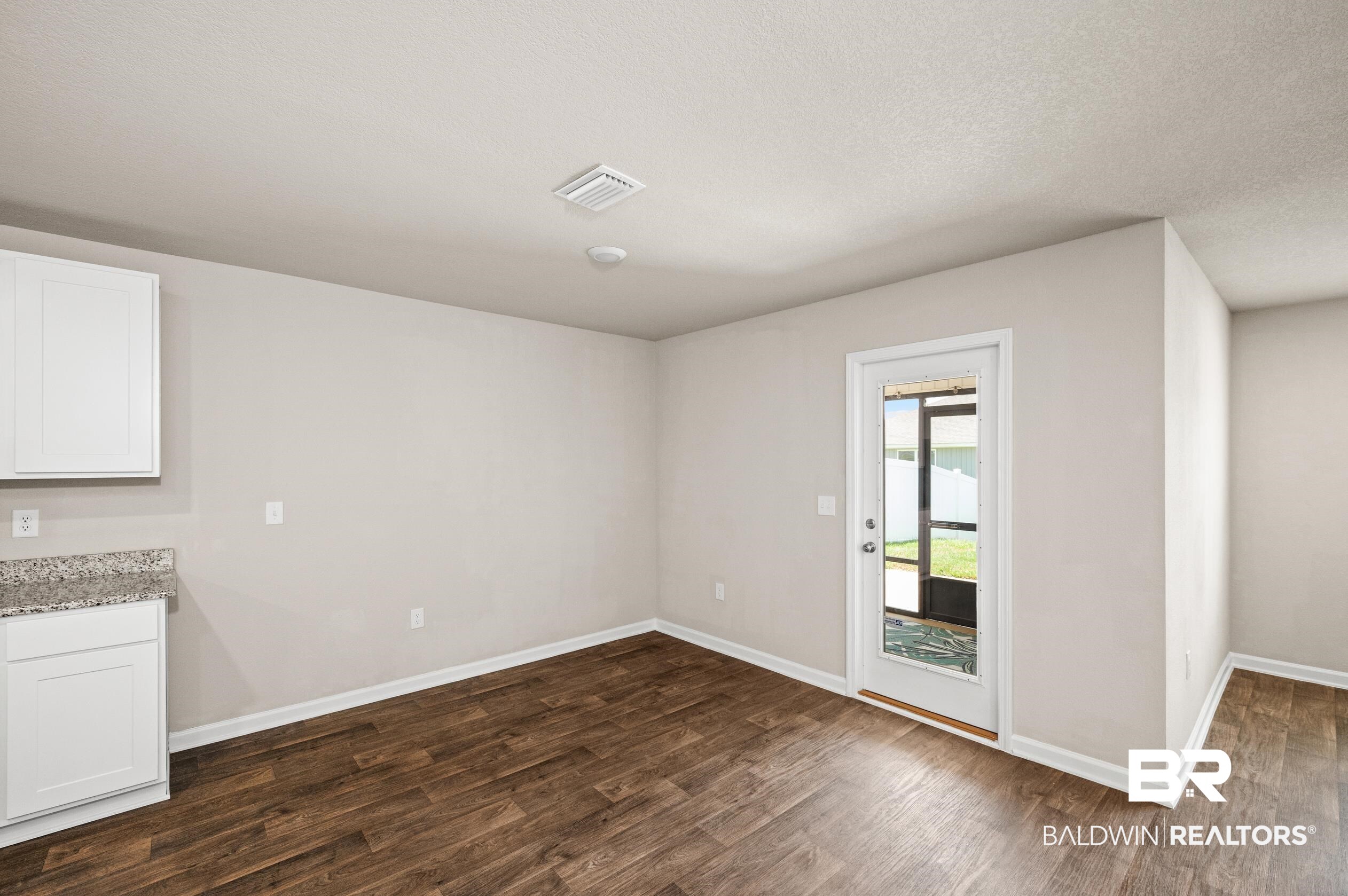10353 Zenyatta Loop Daphne, AL 36526 - Photo 9 of 33 Unfurnished dining area featuring a textured ceiling and hardwood / wood-style floors