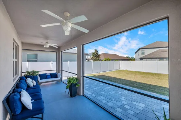 a view of a living room with a floor to ceiling window and wooden floor