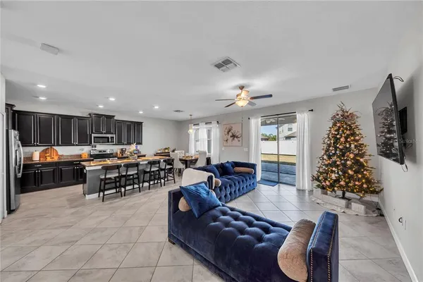 a living room with furniture kitchen and a chandelier