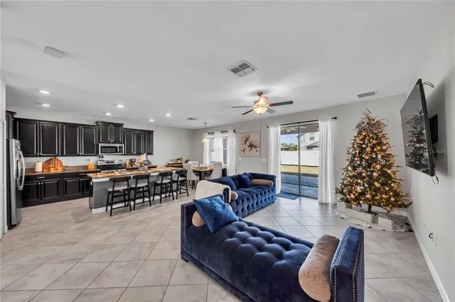 a living room with furniture kitchen and a chandelier