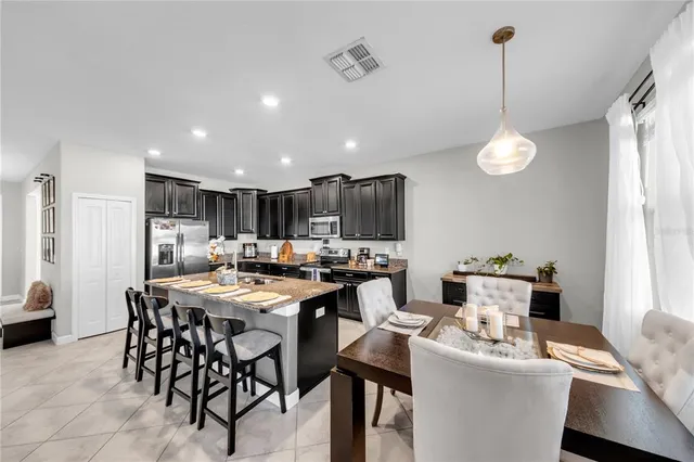 a kitchen with a dining table chairs and white cabinets