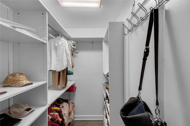 a view of walk in closet with clothes and shoes