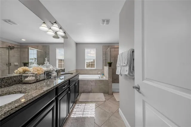 a large bathroom with a granite countertop sink a toilet and bathtub