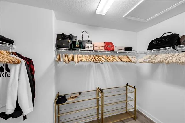 a view of walk in closet with clothes and shoes