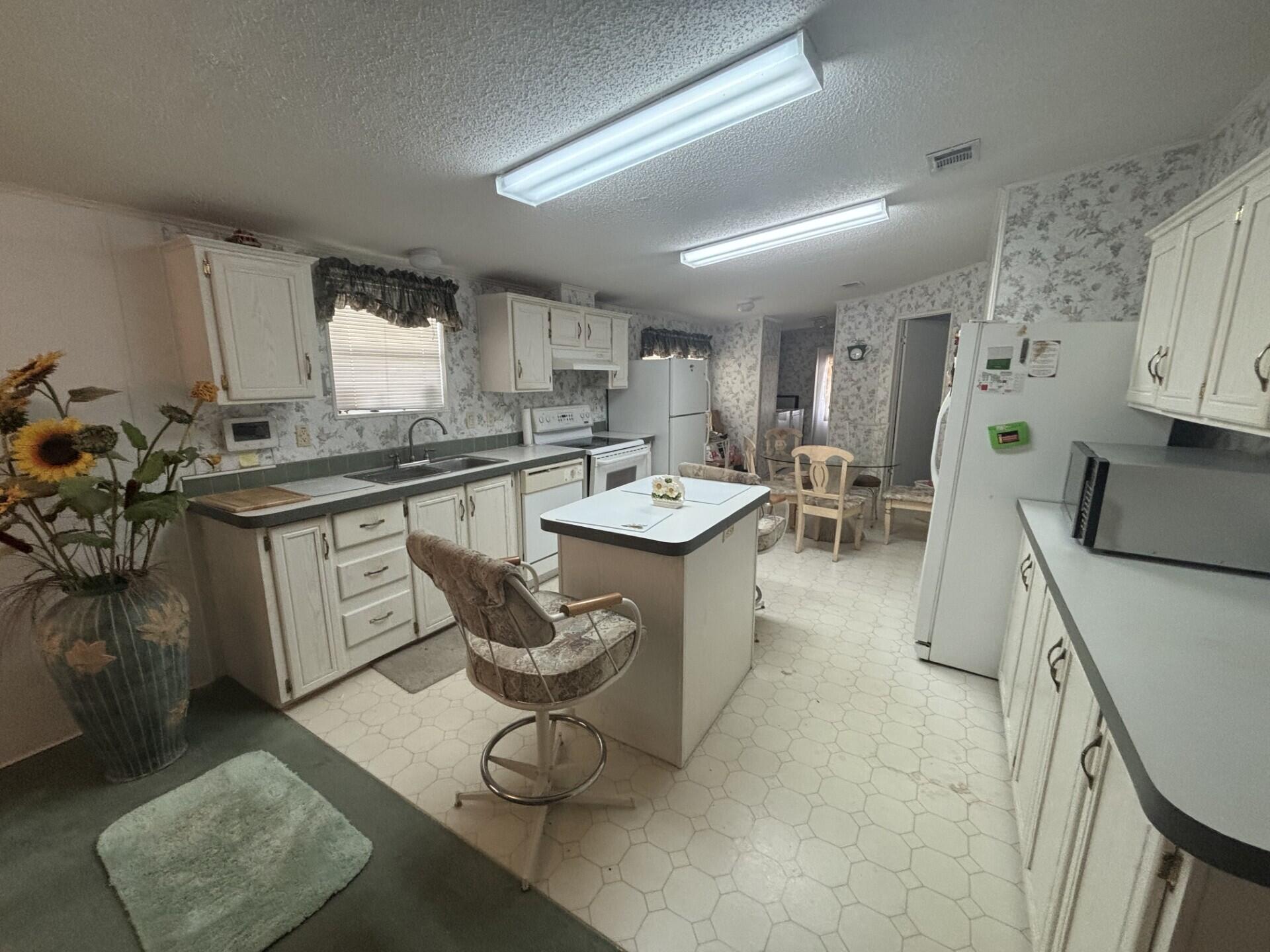 13281 Southwest 10th Manor Davie, FL 33325 - Photo 14 of 43 a kitchen with stainless steel appliances granite countertop a sink a stove a dining table and chairs