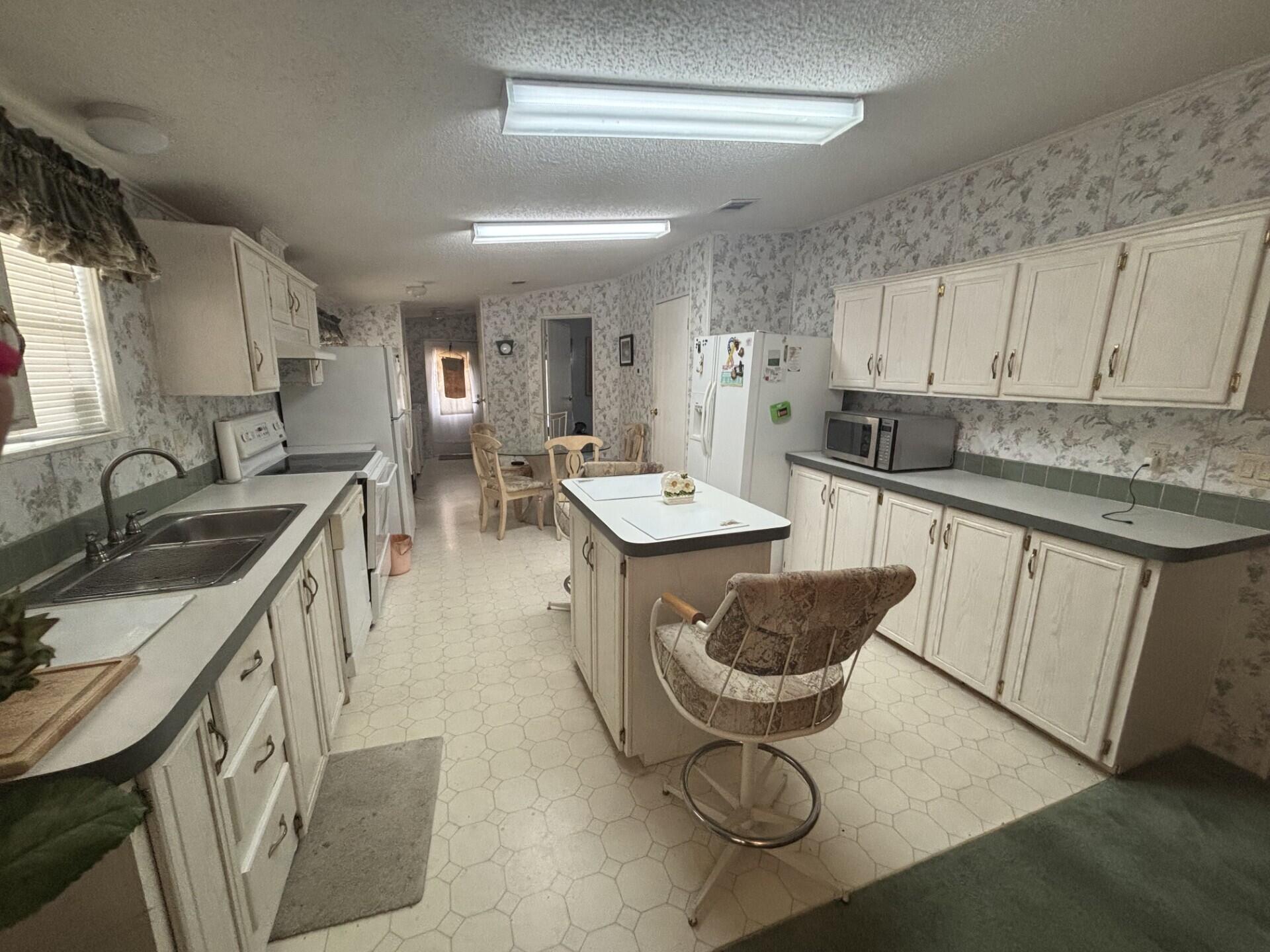 13281 Southwest 10th Manor Davie, FL 33325 - Photo 15 of 43 a kitchen with granite countertop a sink stove and cabinets