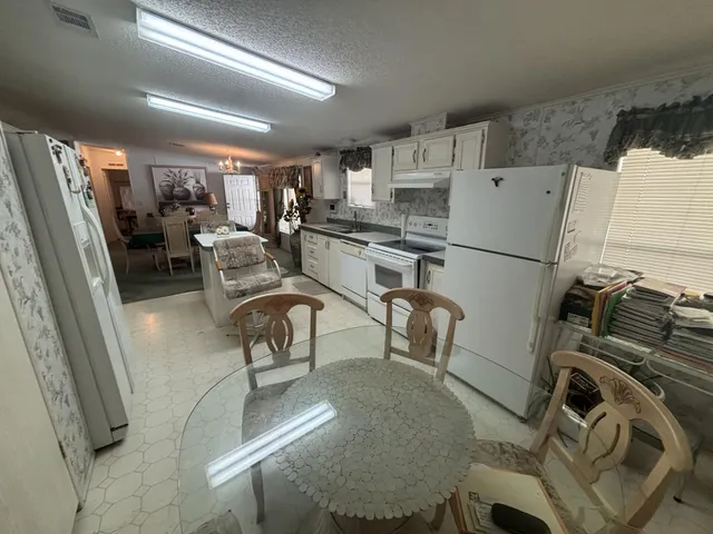 a view of a kitchen with furniture and a refrigerator