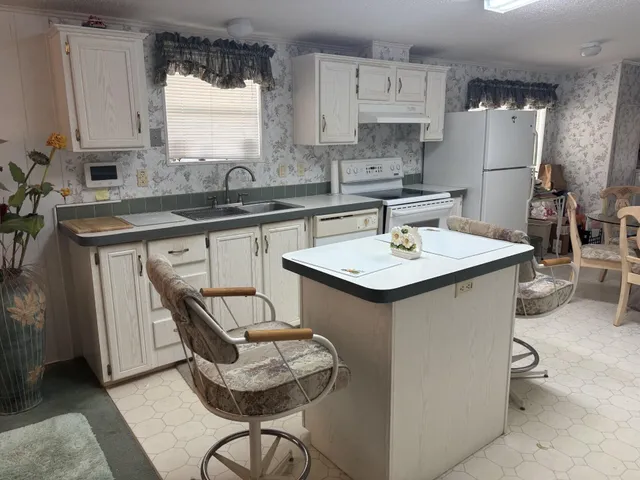 a kitchen with a sink refrigerator and cabinets