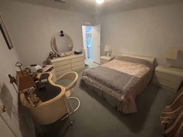 a bedroom with a bed chair and a desk