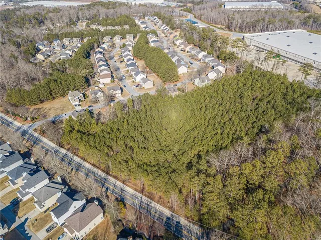 an aerial view of residential houses with outdoor space and trees