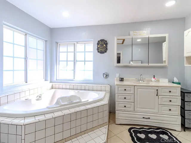 a bathroom with a tub sink and mirror