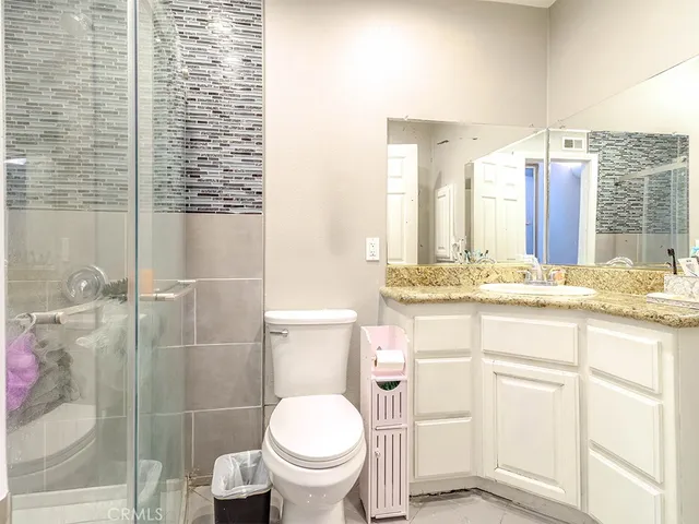 a bathroom with a granite countertop sink toilet and shower